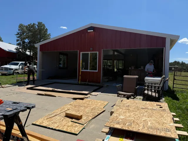 Red post-frame building exterior during the remodel