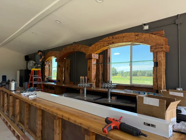 Bar back with arched timber window frames during installation