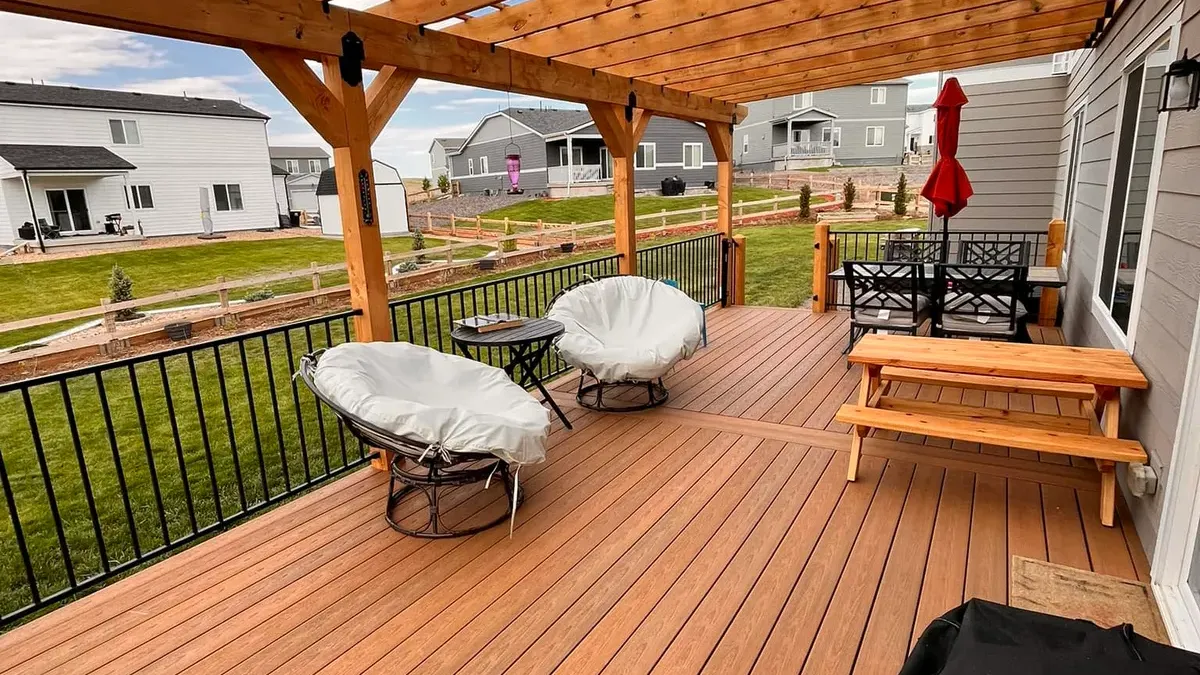Composite deck under a cedar pergola with seating and a picnic table