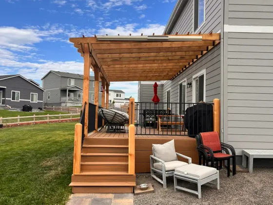 Raised deck with a cedar pergola and steps down to a gravel patio