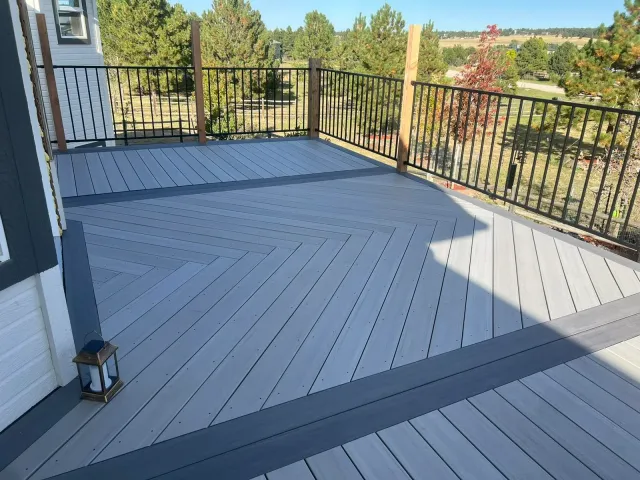 Gray composite deck with a herringbone inlay and dark picture-frame border