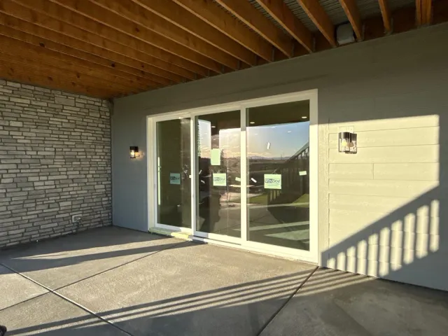 Covered concrete patio with a tongue-and-groove wood ceiling outside sliding doors