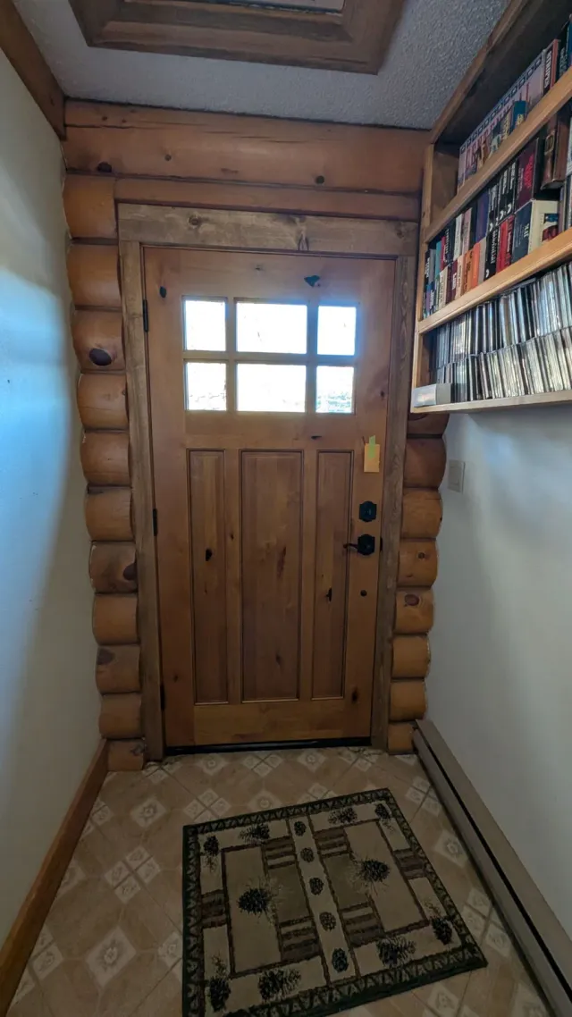 Interior view of a wood entry door trimmed into a log wall