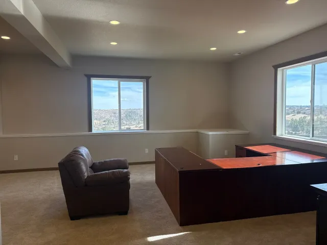 Finished basement family room with carpet and large windows