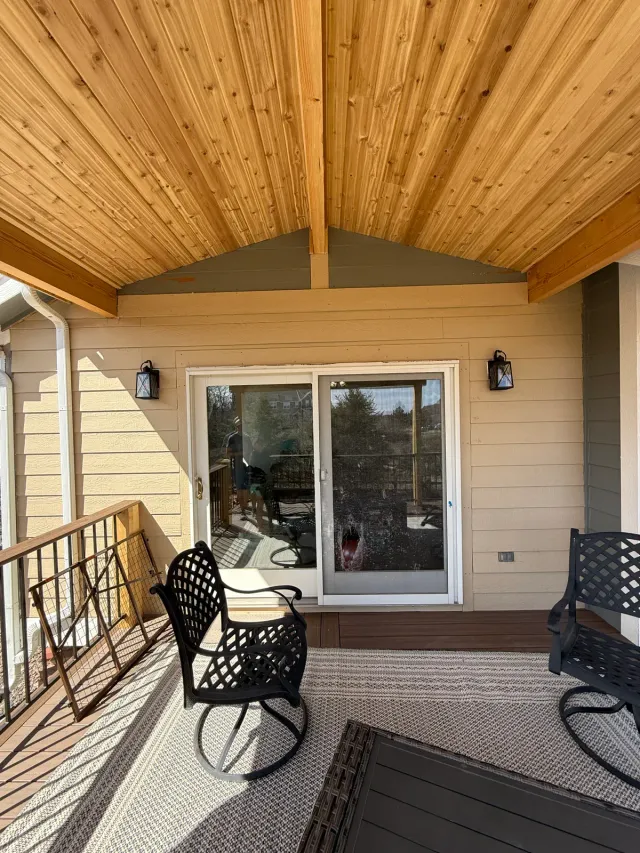 Covered deck with a tongue-and-groove cedar ceiling and patio chairs
