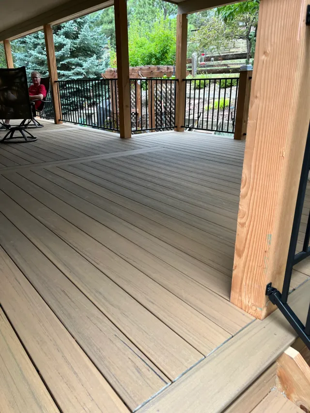 Covered composite deck with stained timber posts and black railing