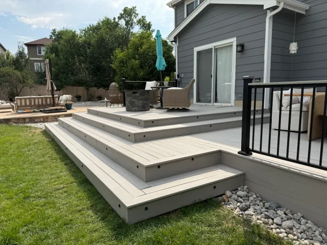 Low multi-level composite deck with wraparound steps down to the lawn