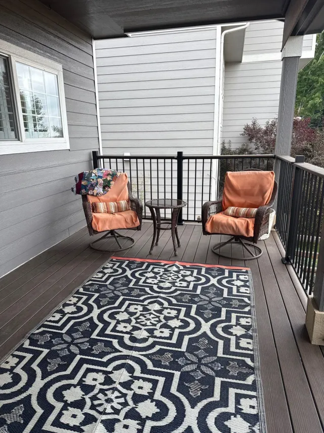 Covered deck seating area with dark composite boards and black railing