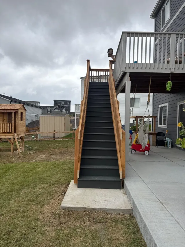 Straight exterior stair with wood railing down from an upper deck