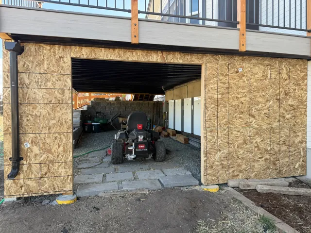 Under-deck storage enclosure sheathed in OSB during construction