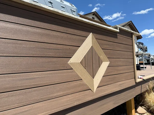 Diamond inlay detail on a brown composite deck wall