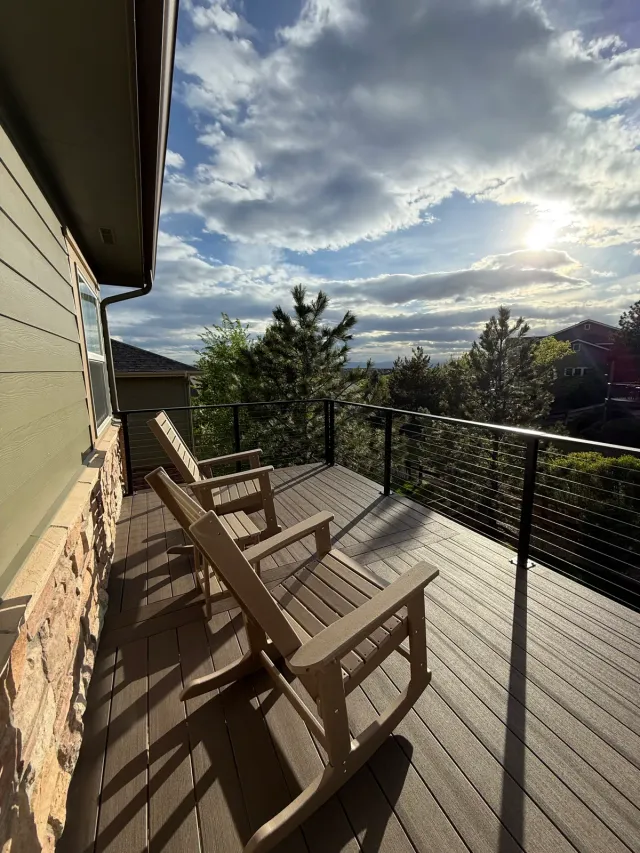 Narrow composite deck with cable railing and rocking chairs