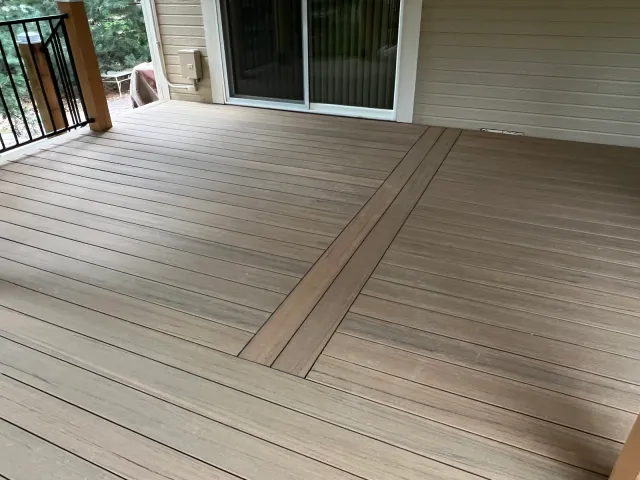Composite deck with a contrasting divider-board pattern outside sliding doors