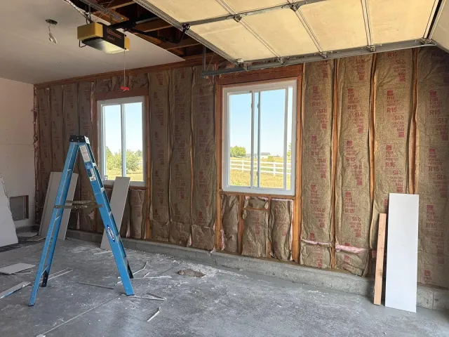 Garage walls filled with batt insulation before drywall