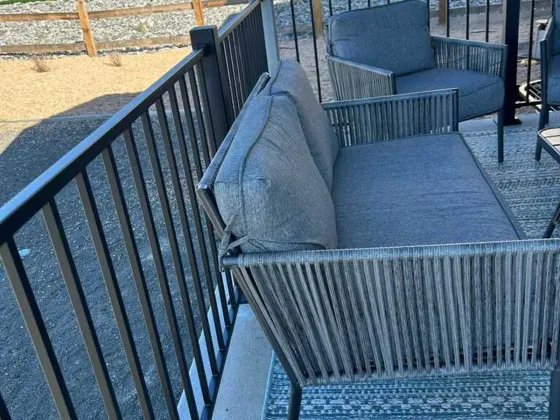 Black metal porch railing alongside outdoor seating