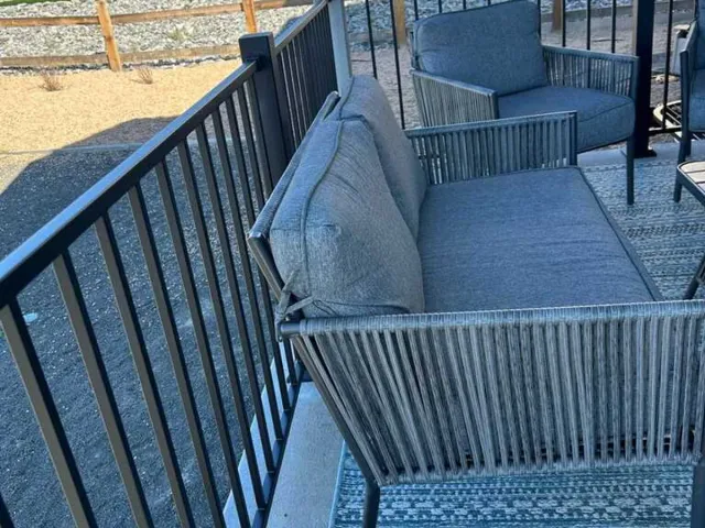 Black metal porch railing alongside outdoor seating