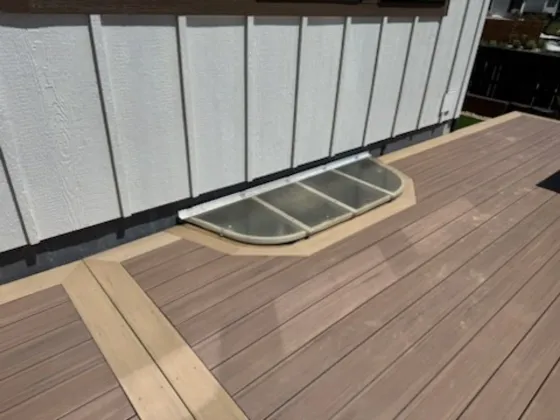 Composite decking with a light border cut around a basement window well