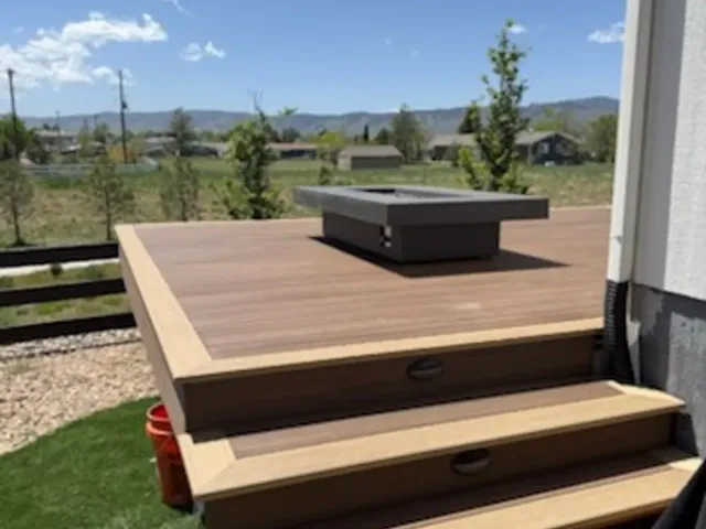 Low composite platform with wraparound steps and a fire pit table