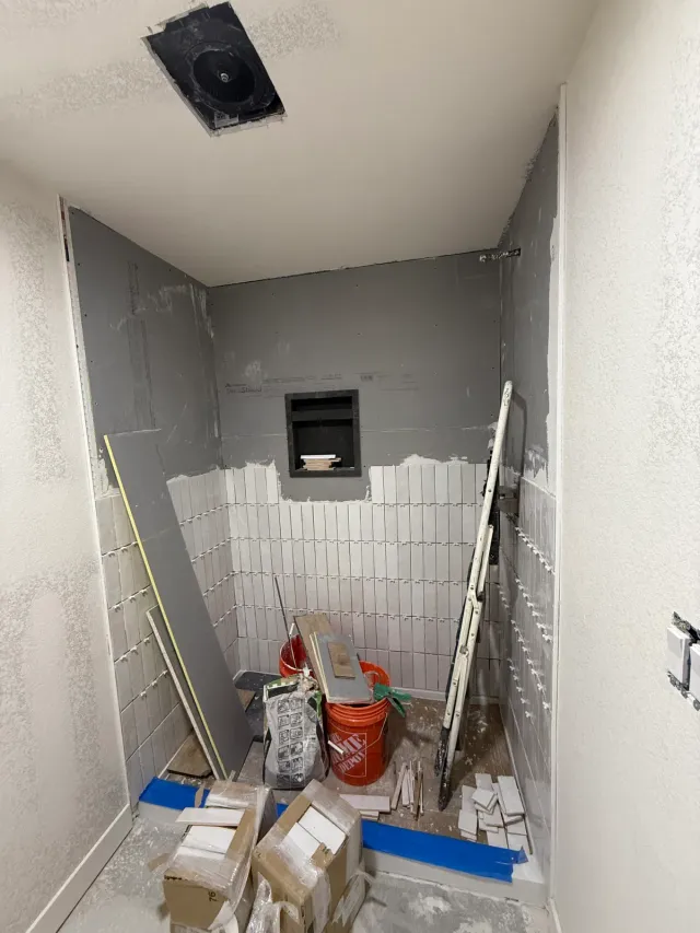 Shower partway through tiling, with a recessed niche