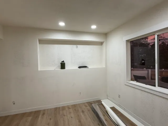 Basement room with a recessed wall niche during flooring installation