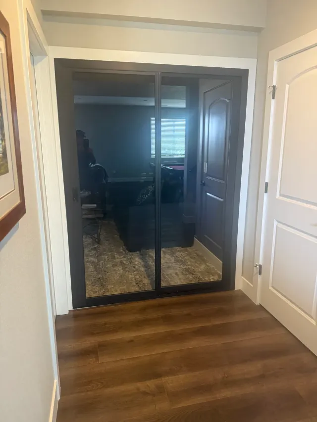 Sliding glass doors into a home office, with wood-look flooring