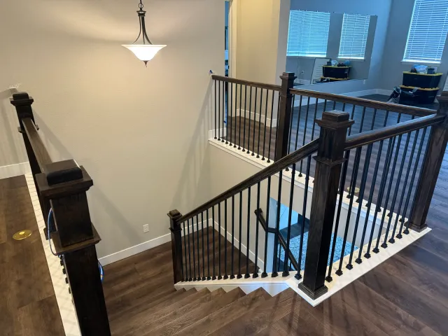 Interior staircase with dark wood newel posts and black iron balusters