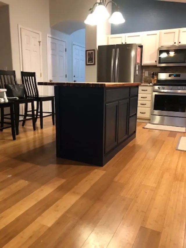 Navy kitchen island with a butcher-block top